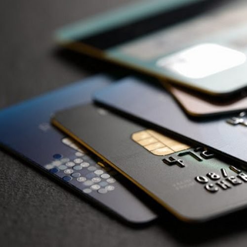 stack of multicolored credit cards on black background