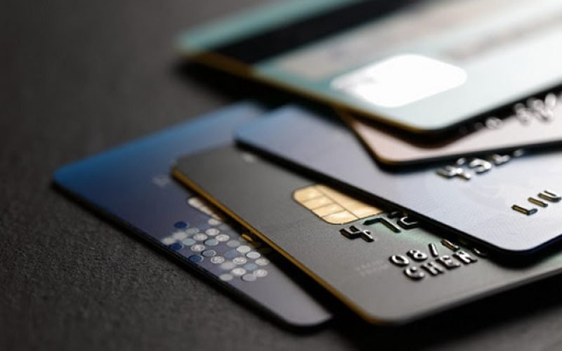 stack of multicolored credit cards on black background