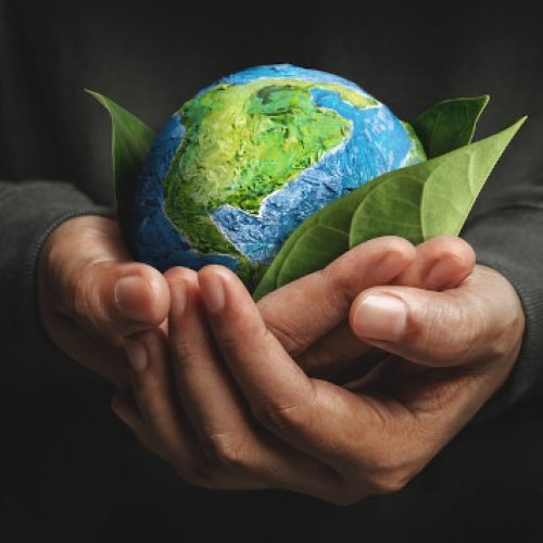 World Earth Day Concept. Green Energy, ESG, Environmental, social and corporate governance. Renewable and Sustainable Resources. Environmental and Ecology Care. Hand Embracing Green Leaf and Globe