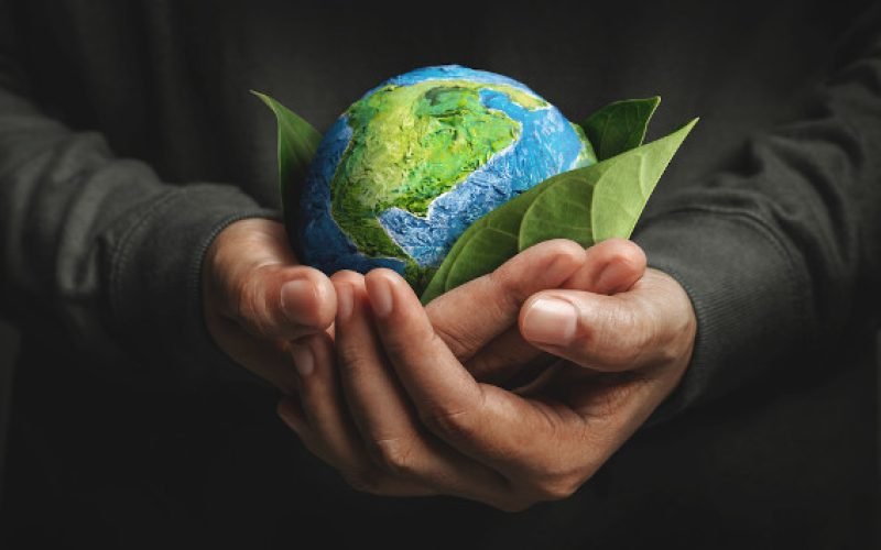 World Earth Day Concept. Green Energy, ESG, Environmental, social and corporate governance. Renewable and Sustainable Resources. Environmental and Ecology Care. Hand Embracing Green Leaf and Globe